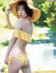 A woman in a yellow bikini and a straw hat.