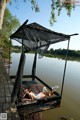 A woman laying on a dock next to a body of water.