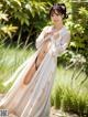 A woman in a long white dress posing for a picture.