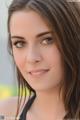 A beautiful young woman with long brown hair posing for a picture.