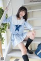 A woman in a school uniform sitting on a stairway.