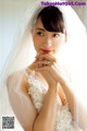 A woman in a wedding dress with a veil over her head.