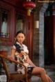 A woman sitting on a chair in front of a building.