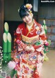 A woman in a kimono standing in front of a building.